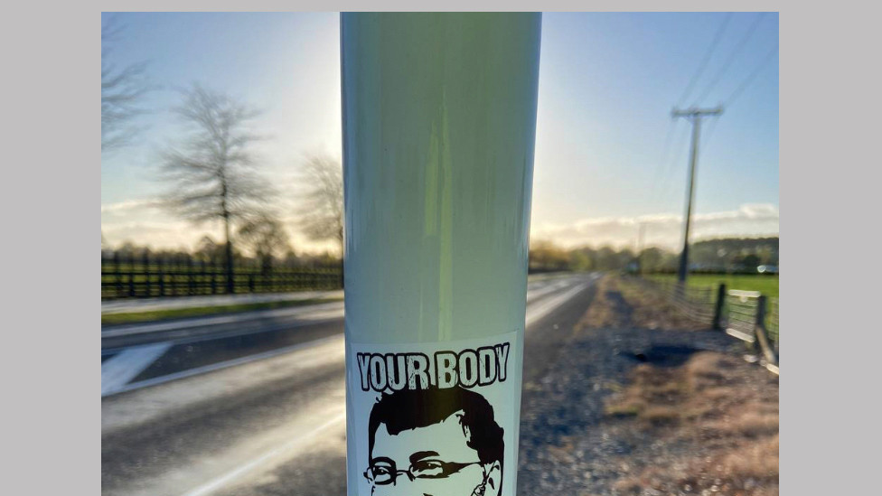 a sticker with Bill Gates head and the slogan "Your body my choice"