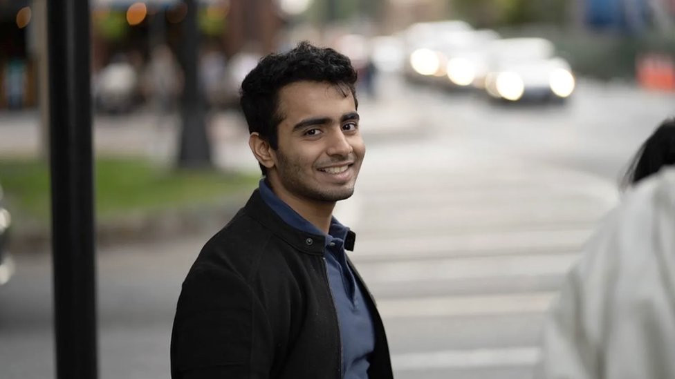 Angad Daryani standing in a street with a queue of traffic behind him