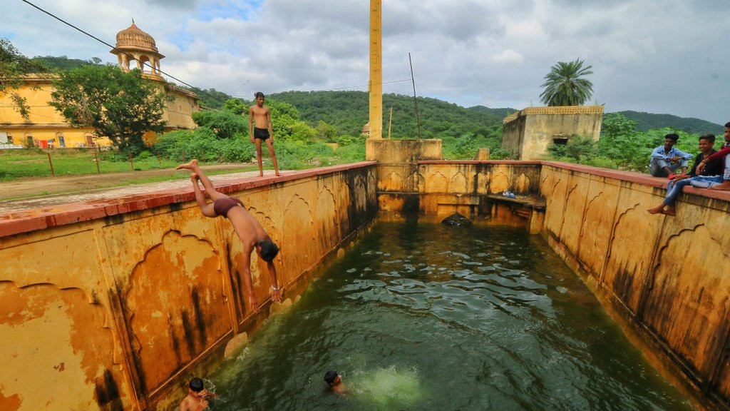 Children jump into a step-well (baori) after it was filled with rain water, near Man Sagar Lake in Jaipur, Rajasthan, India