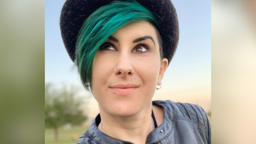 Lyric Holmans smiles while looking away from the camera.