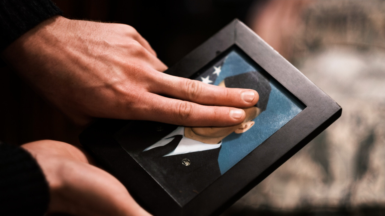 Max using his fingers to conceal his face on a photograph of himself as an airman