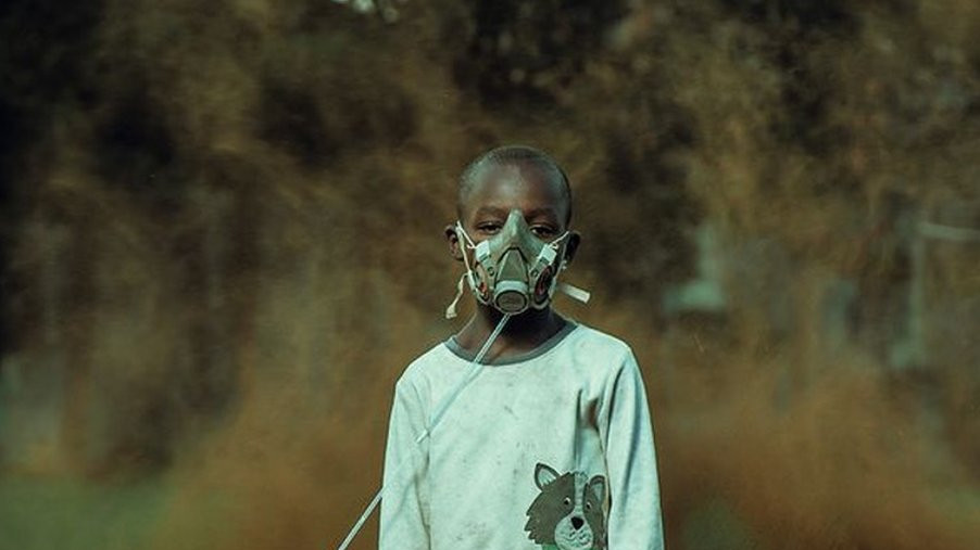 Boy in mask attached to plant pot