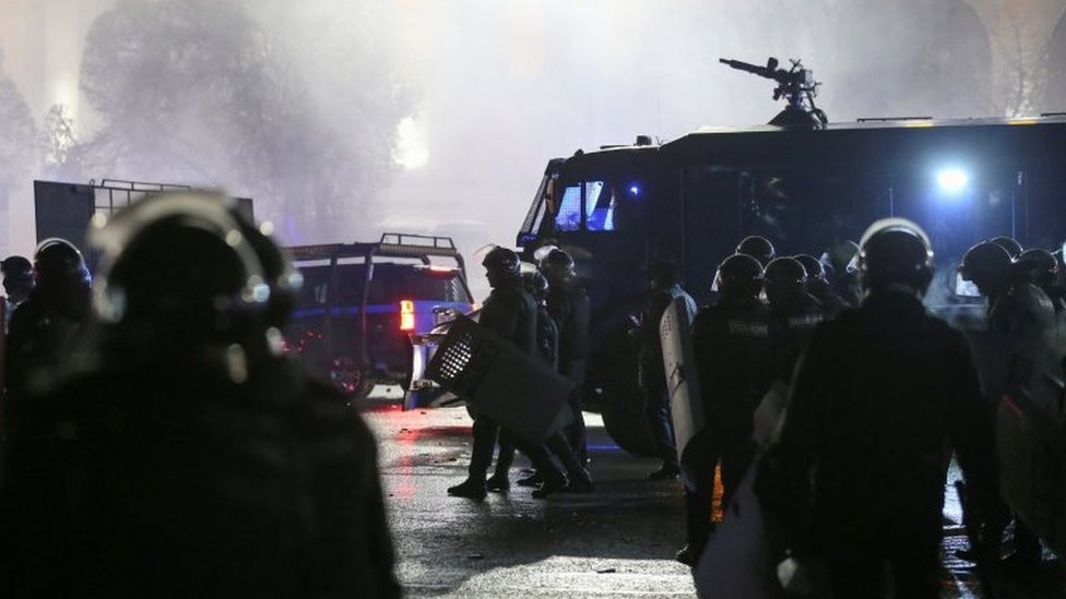 Kazakh law enforcement officers gather in a square during a protest against LPG cost rise