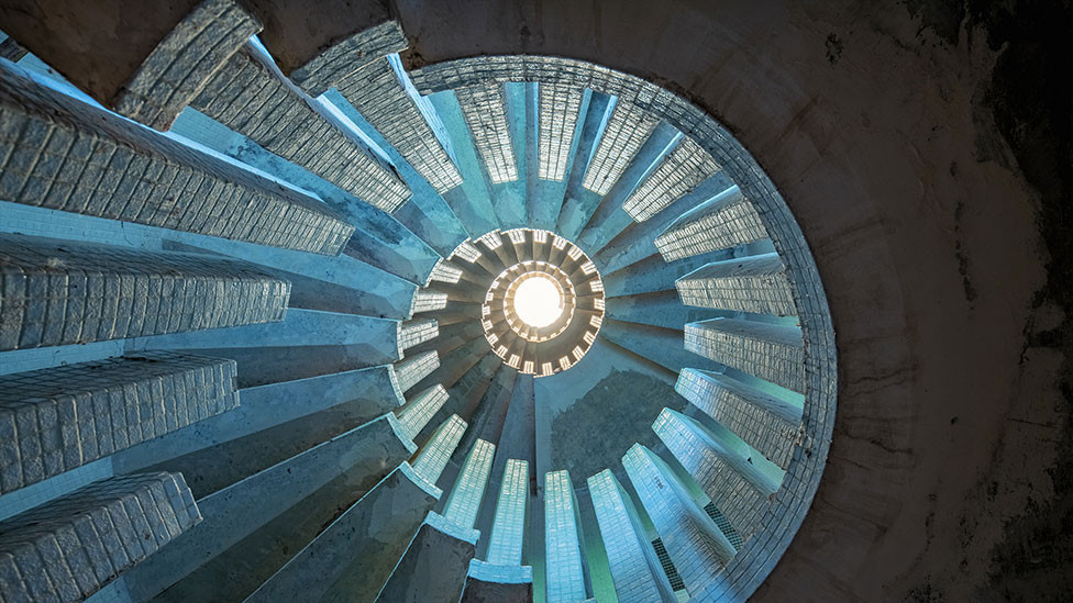 A view upward at a concrete staircase in an abandoned manor in Wimbledon, UK