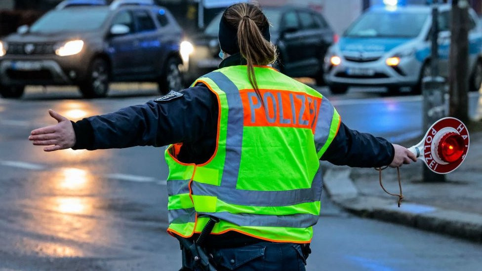 A German police officer directs traffic during a protest in berlin, January 2022