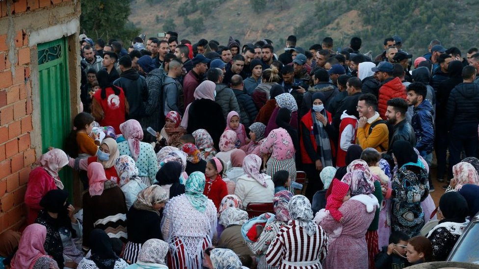 People gather close tot he rescue site on 3 February.