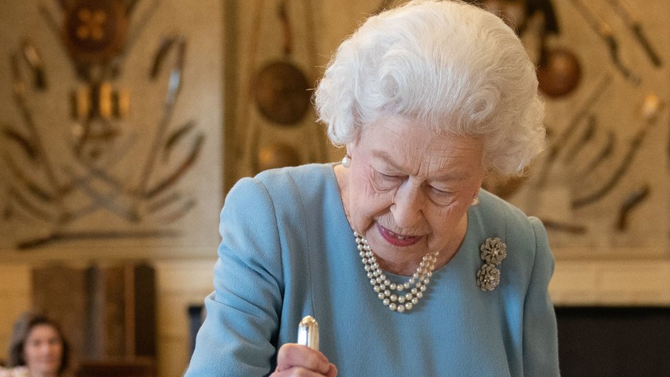 Queen Elizabeth II cutting a cake
