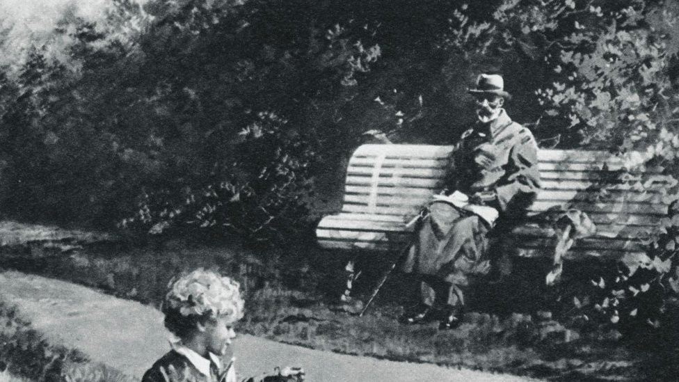 Lilibet builds a sandcastle, watched over her grandfather, sat on a bench in Bognor in 1929