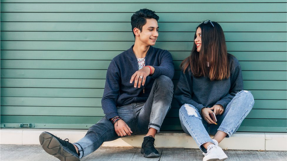 A smiling couple sitting on the floor