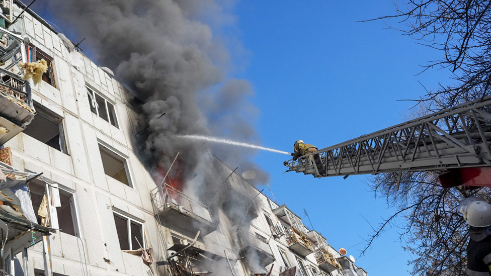 Ukrainian firefighters try to extinguish a fire after an airstrike hit an apartment complex in Chuhuiv, Kharkiv Oblast, Ukraine on 24 February 2022