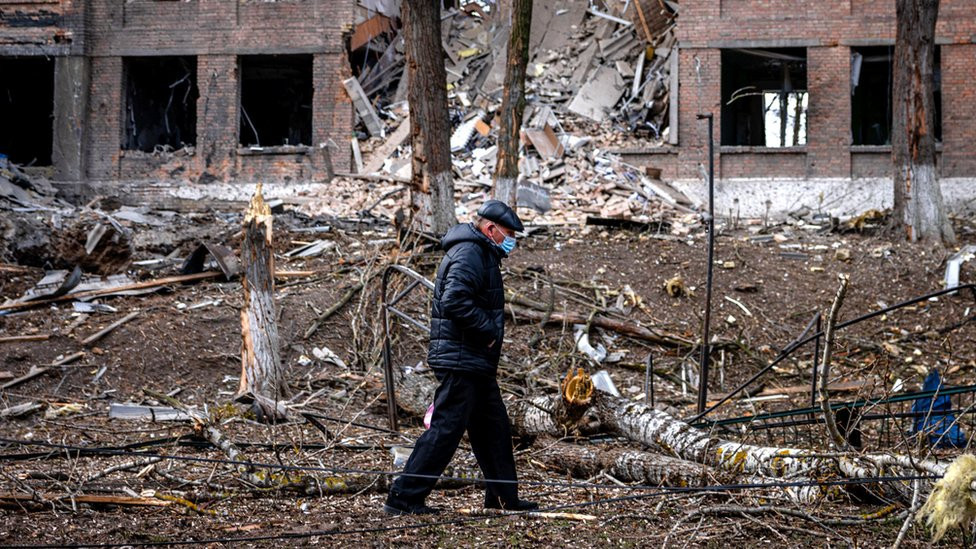 A man walks in front of a destroyed building after a Russian missile attack in the town of Vasylkiv, near Kyiv, on 27 February 2022