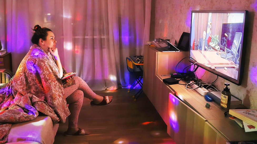A woman in St Petersburg watching President Putin on TV last week