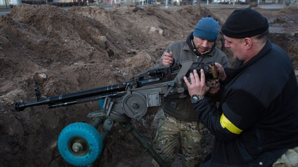 Members of the territorial defense battalion set up a machine gun and organise a military redoubt on 25 February in Kyiv