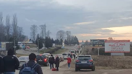 A queue of cars and people walking in an area close to the Polish border in Ukraine