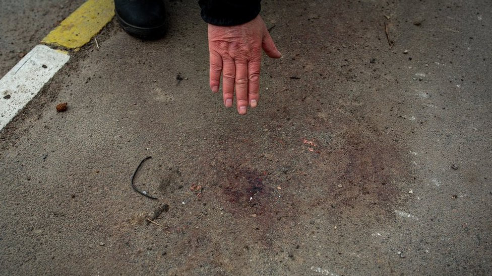 Vladimir Abramov pokazuje na mesto na trotoaru ispred njihove kuće gde kaže da je njegov zet bio prisiljen da klekne i gde mu je pucano u glavu