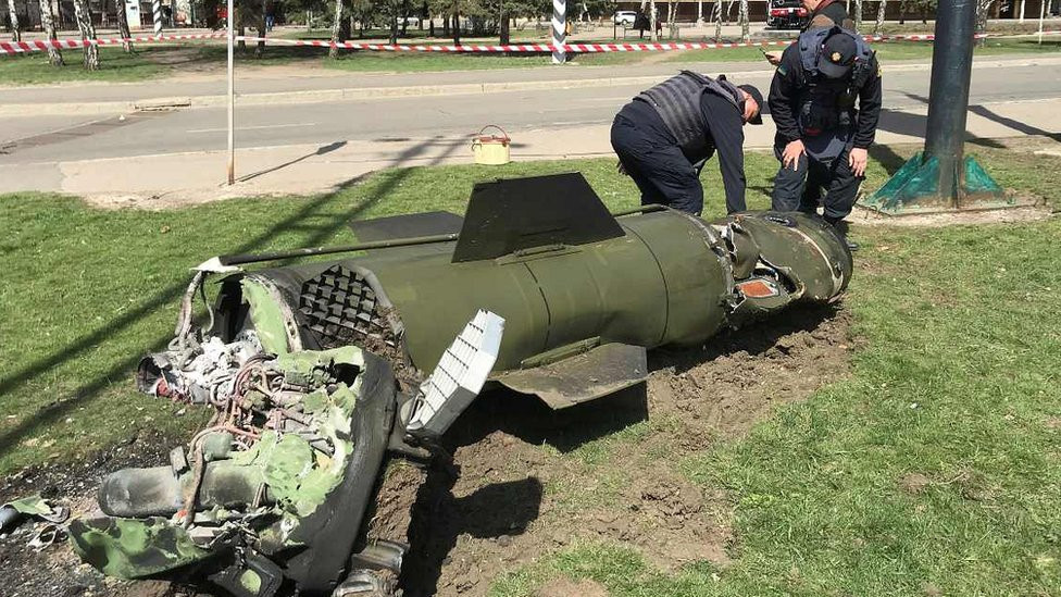 Two Ukrainian personnel looking at missile remains