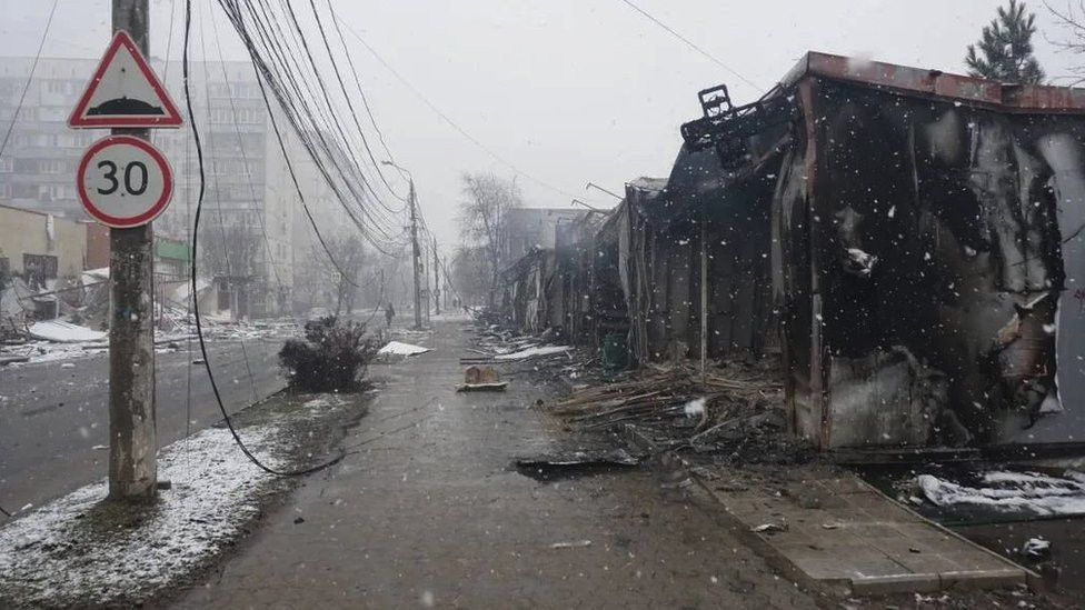 A Mariupol street with damaged buildings and rubble strewn across the ground