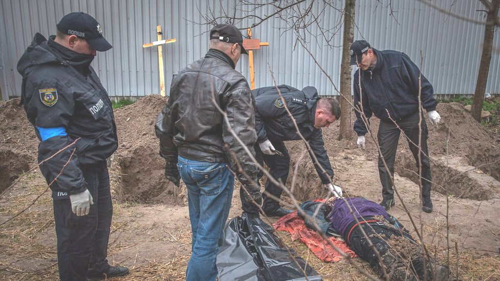 Police in Bucha examine a body unearthed in a field. At least 500 dead have been found since the Russians left