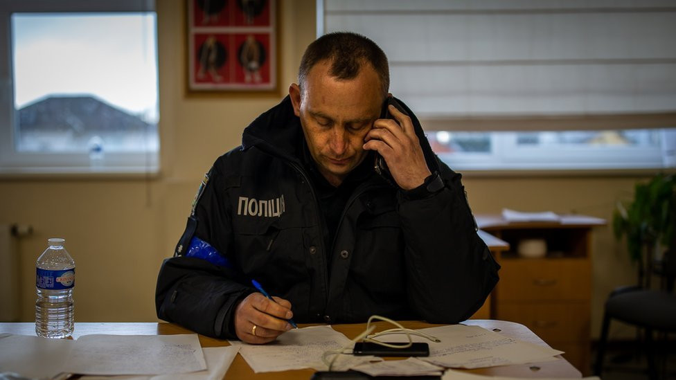 Vitaliy Lobas, the head of Buchansky District 1 police department, takes a call in his command post in a school classroom.