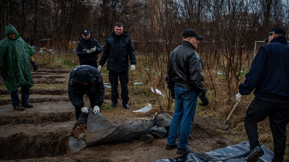 Nine graves, dug by neighbours behind apartment buildings in Bucha.