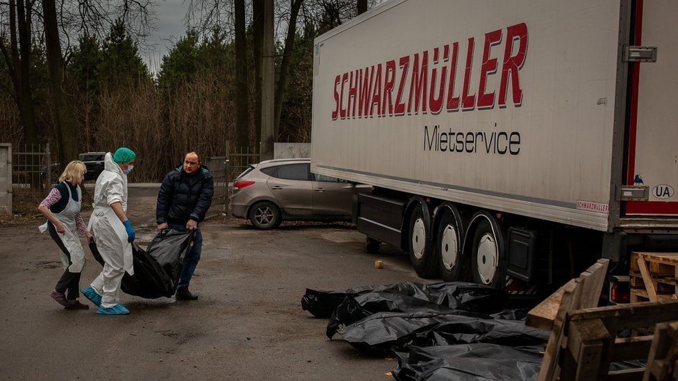 Serhiy Brezhnev helps carry Vitaliy's body bag out from the morgue, to await fingerprinting.