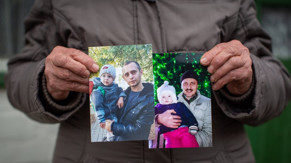 Nadia Holumenkov holds pictures of her grandson Nikita and son Oleksandr