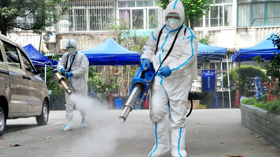 Staff members wearing personal protective equipment (PPE) disinfect a residential community on 2 May, 2022 in Shanghai, China