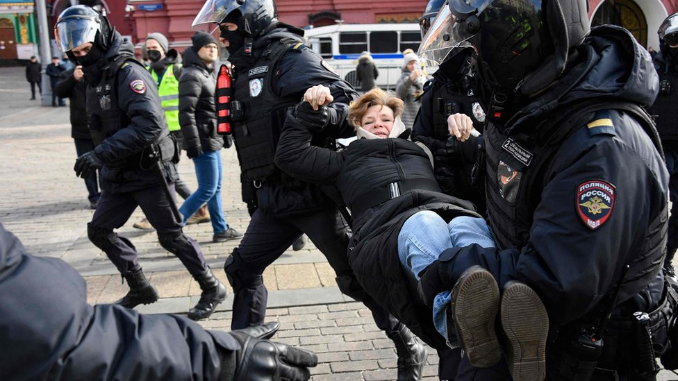 Russian police carry an anti-war protester away