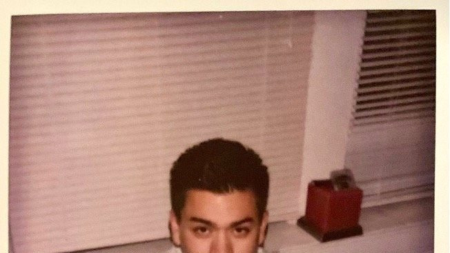 Tom Justice sitting cross-legged on the floor in front of windows