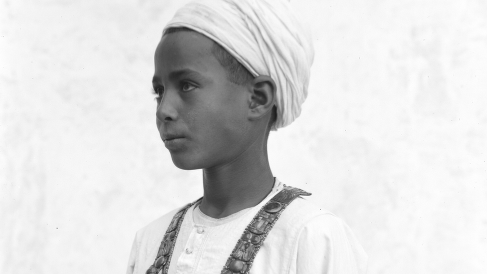 An Egyptian boy models a jewelled necklace found in Tutankhamun's tomb
