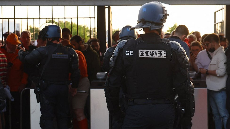 Police officers with fans by the turnstiles at the Stade de France