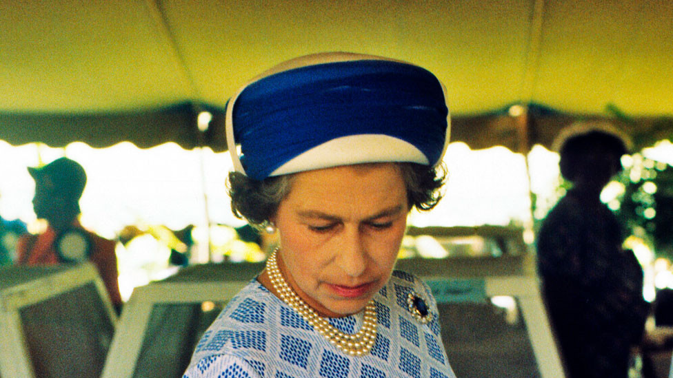 Queen Elizabeth ll inspects a mango