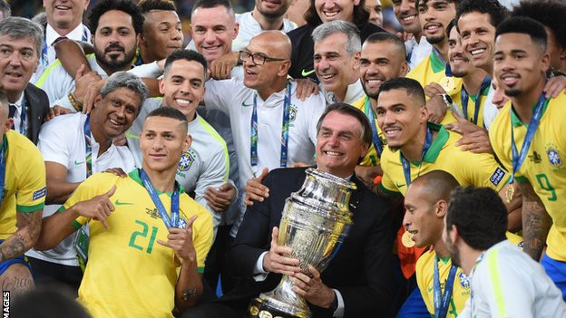 Bolsonaro poses with the Copa America trophy after Brazil's 2019 victory