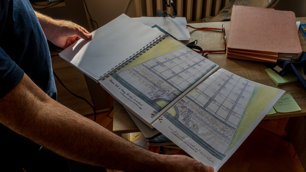 Mansoor Adayfi shows a drawing from his business plan for a milk and honey farm in Yemen, completed in Guantanamo.