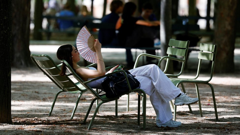 Image shows woman fanning herself