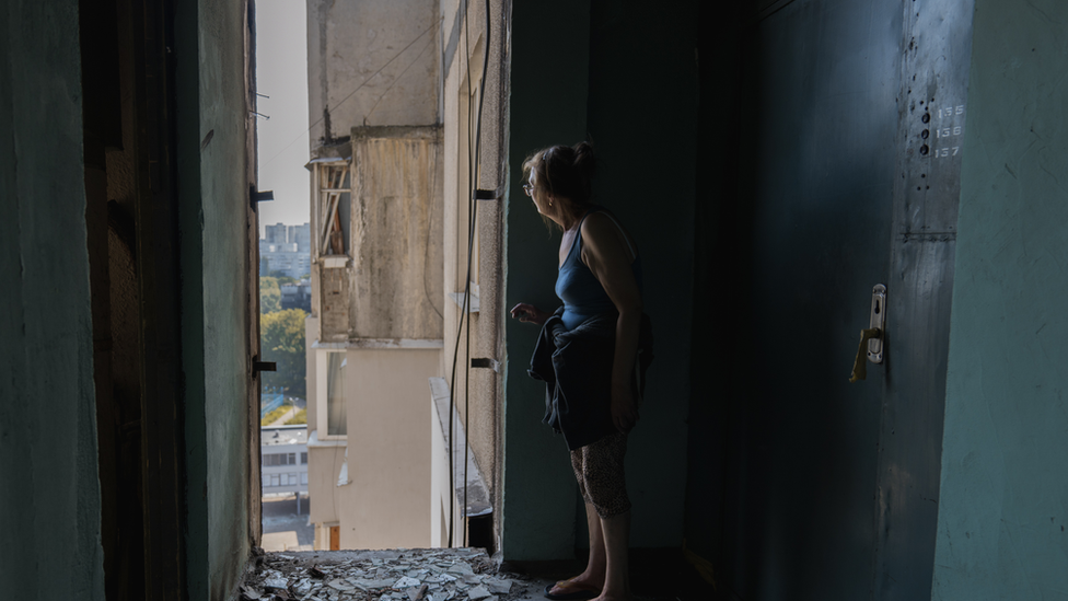 Larisa looks out from her hallway on the 16th floor. She is worried the building will collapse