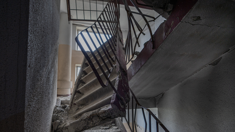 The concrete stairwell two floors above Roman's apartment, smashed by a direct hit on the roof