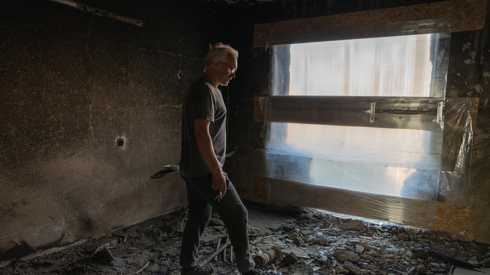 Boris Rustenko rests his foot on rocket shrapnel in his building. "Ukraine would have attacked Russia," he said. "Russia is just ahead"