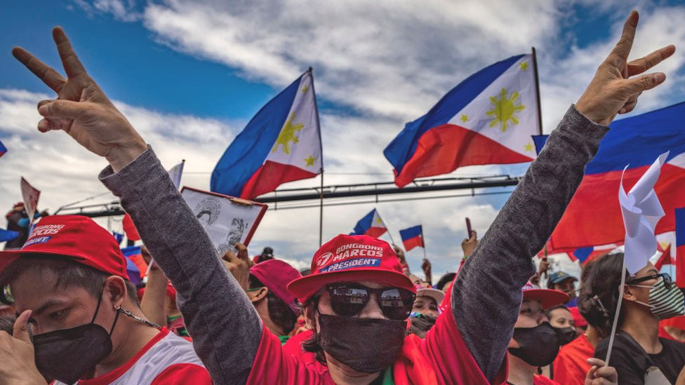 A supporter flashes the peace sign, the campaign symbol of Ferdinand "Bongbong" Marcos Jr., during his last campaign rally before the election on May 07, 2022 in Paranaque, Metro Manila, Philippines.
