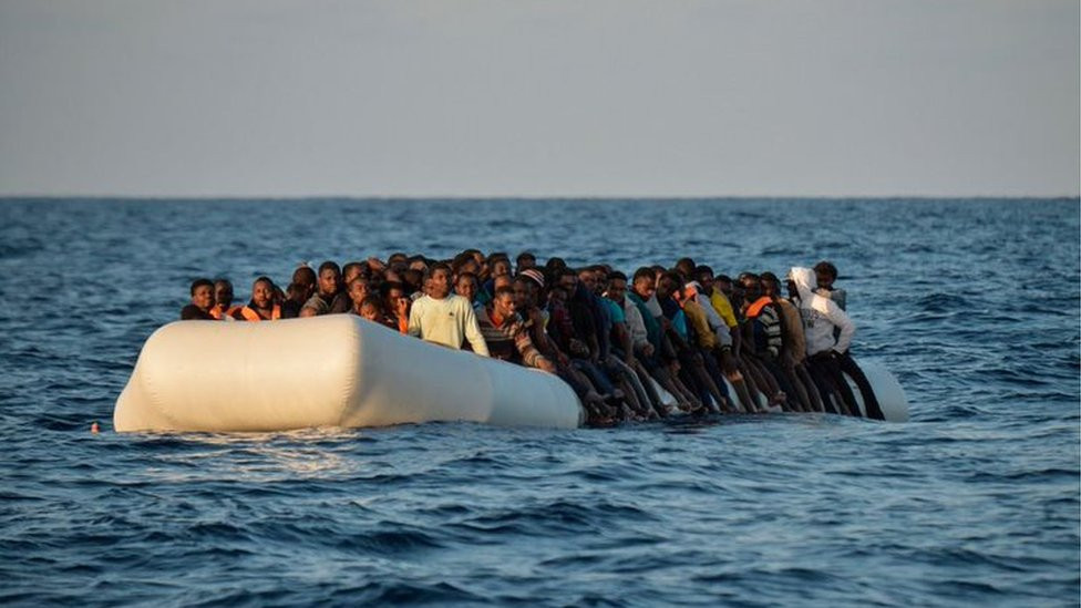 Migrants and refugees sit on a rubber boat before to be rescued by the ship Topaz Responder run by Maltese NGO Moas and Italian Red Cross off the Libyan coast in the Mediterranean Sea, on November 3, 2016