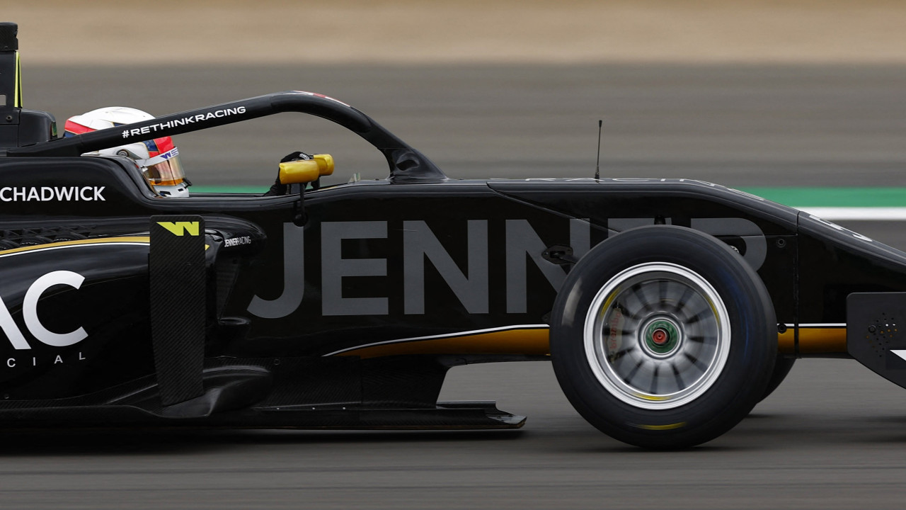 Side view of a black F1 racing car with the halo device