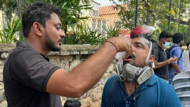 man drinking water after being tear gassed