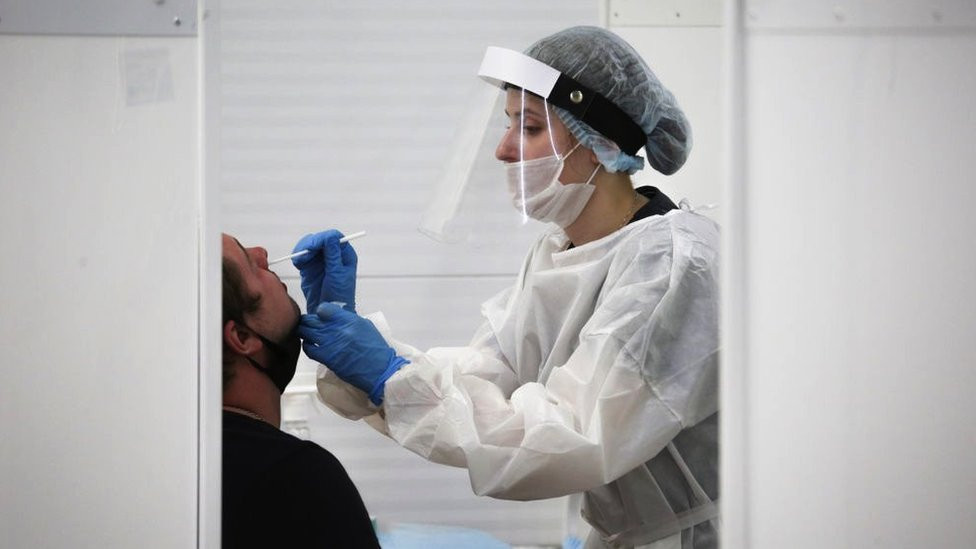 A medical professional conducts a nasal swab