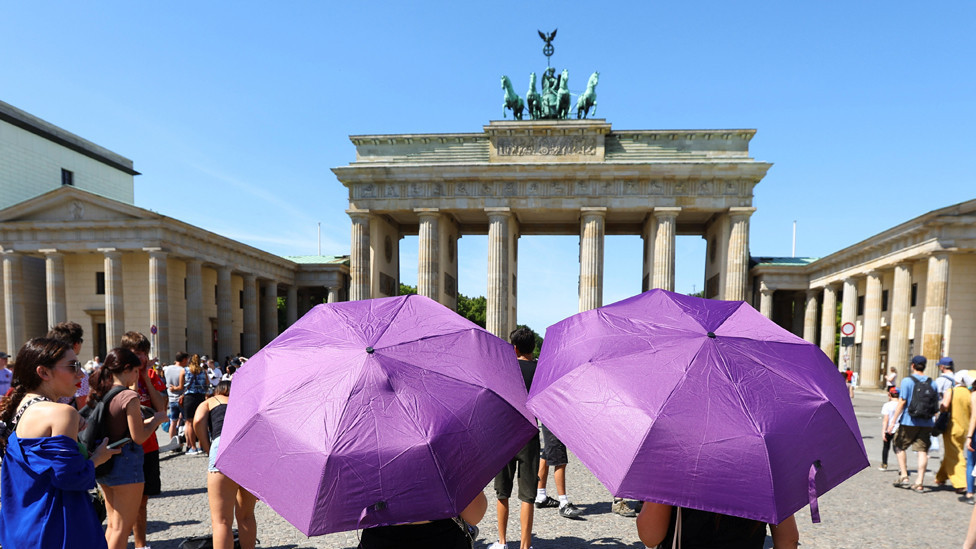 Toplotni talas u Nemačkoj - turisti u šetnji po gradu sa kišobranima