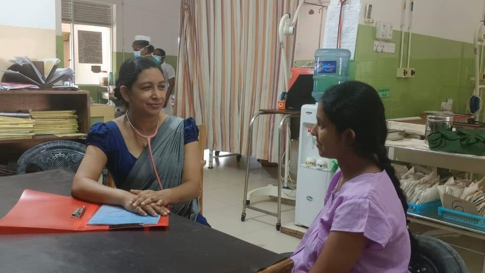 Dr Iresha Mampitiya, a senior lecturer at the University of Ruhuna, sat at a desk speaking to a woman