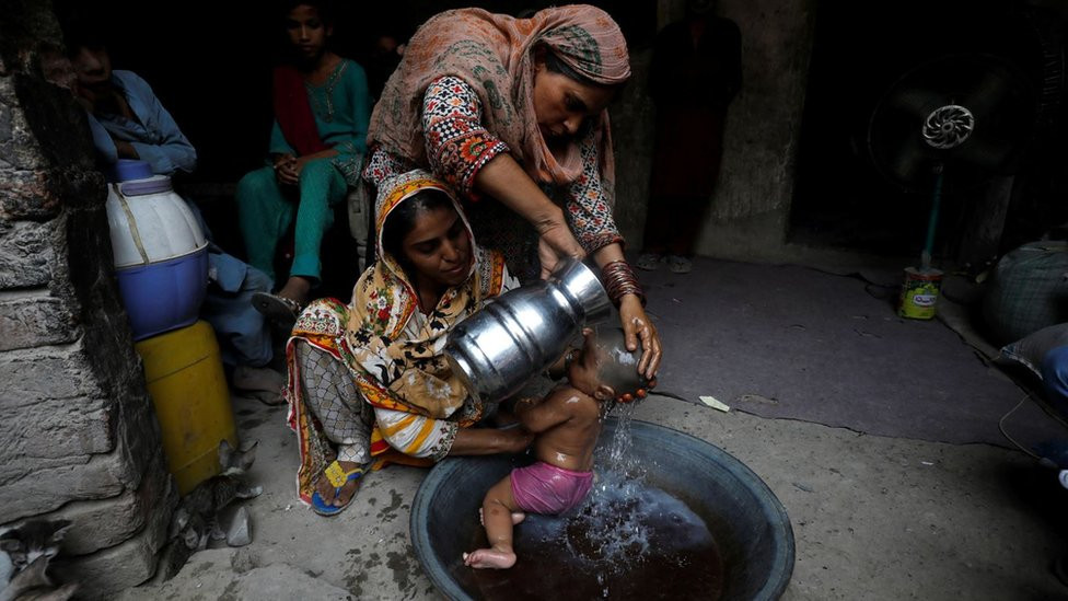 dve žene kupaju dete