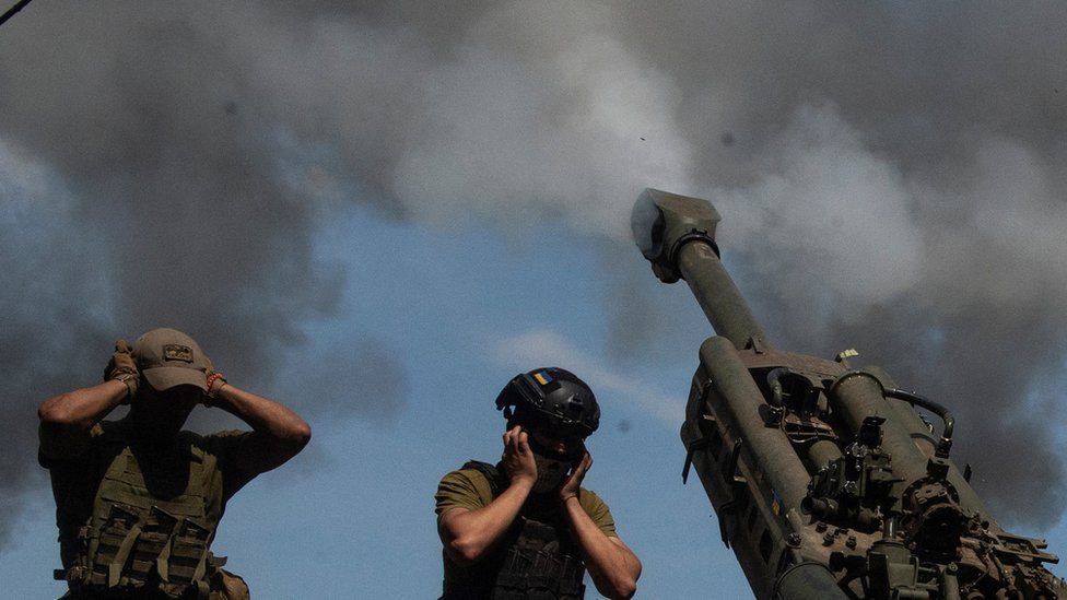 Ukrainskie voennoslužaщie zažimaюt uši vo vremя vыstrela gaubicы M777 1 avgusta 2022 goda