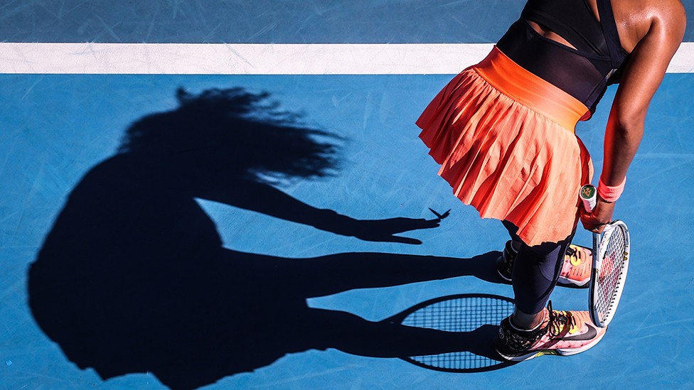 Naomi Osaka sklanja leptira sa opreme tokom meča Australijan opena 12. februara 2021. godine
