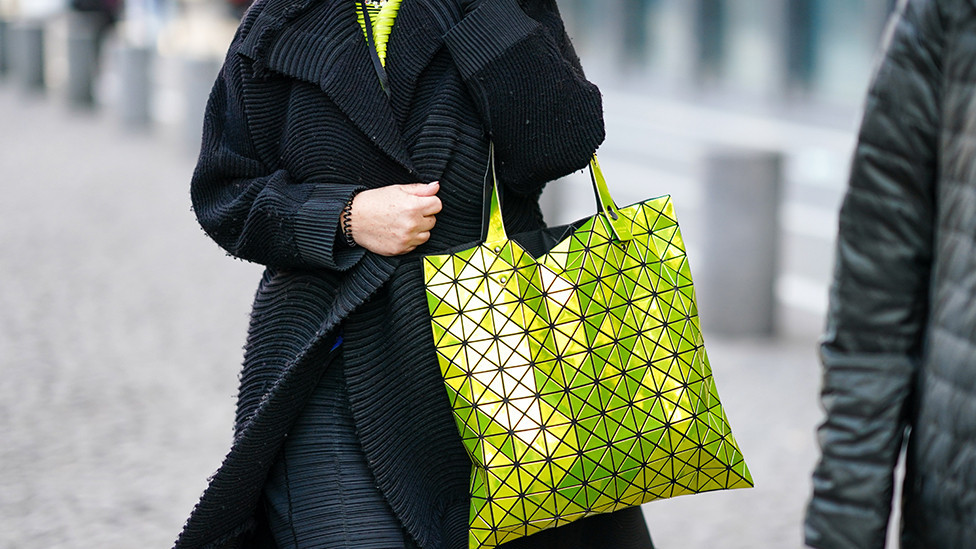 Gost na reviji nosi žutu torbu Bao Boa na Nedelji mode u Parizu 2020. godine. Prepoznatljiva po malim trouglovima od smole, postala je toliko popularna da su tržiše preplavile razne kopije