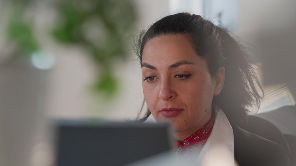Angela sitting at the laptop